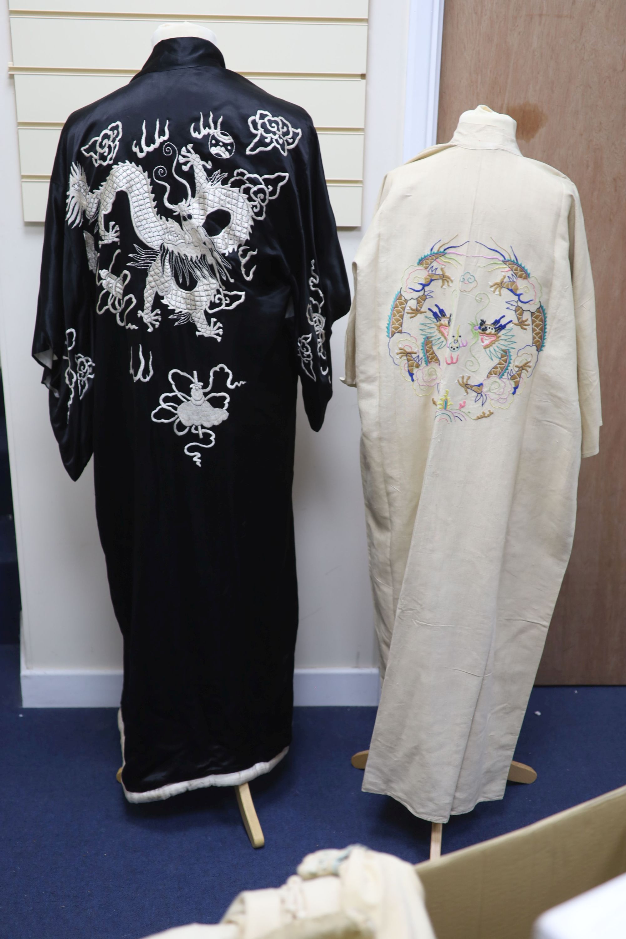 A Japanese black silk satin kimono embroidered with a white silk dragon, 133cm long and a cream silk multi-coloured embroidered dragon